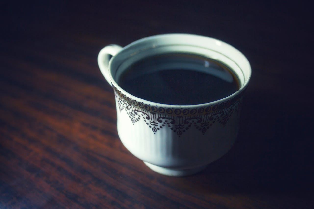 Close-up of a hot cup of black coffee served in an elegant porcelain cup.